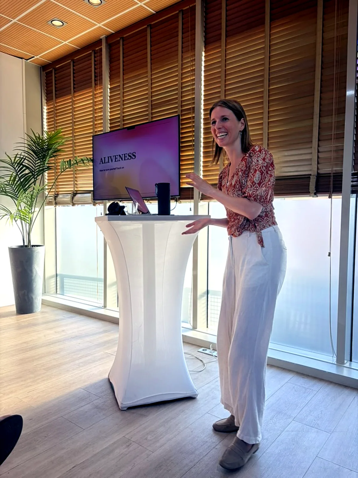 Marjolein van der Krol geeft een talk, met op het scherm achter haar 'Aliveness: how to turn yourself back on'